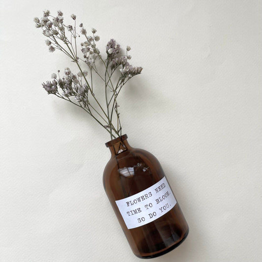 בקבוק זכוכית עם פרחים מיובשים